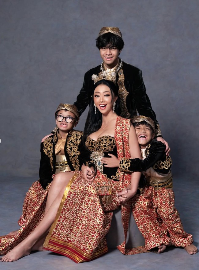 Penampilan Asri dilengkapi aksesori kepala bernuansa tradisional berwarna emas, anting panjang yang berkilau, serta riasan wajah yang lebih bold namun tetap elegan. Foto: Instagram/@riomotret