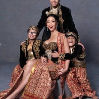 Penampilan Asri dilengkapi aksesori kepala bernuansa tradisional berwarna emas, anting panjang yang berkilau, serta riasan wajah yang lebih bold namun tetap elegan. Foto: Instagram/@riomotret