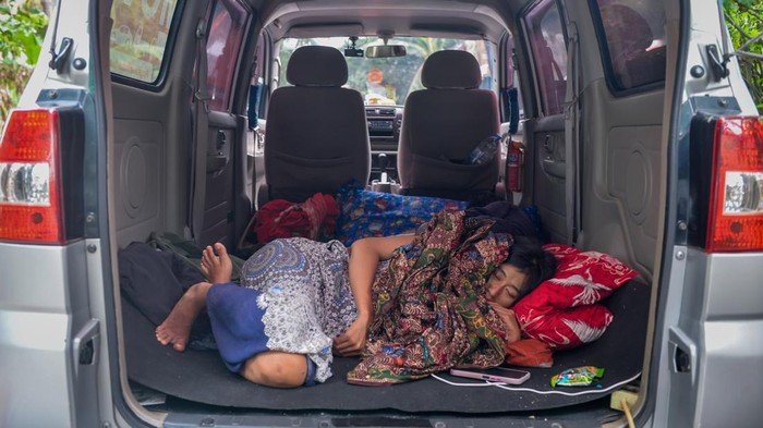 Warga terdampak banjir mengungsi di dalam mobil di Desa Pasir Ampo, Kresek, Kabupaten Tangerang, Banten, Selasa (20/1/2026). Banjir akibat luapan Sungai Cidurian setinggi 30-80 cm yang merendam sebanyak 185 rumah sejak sepekan terakhir tersebut membuat warga kesulitan mendapatkan akses air bersih dan mulai terserang penyakit seperti gatal-gatal, kutu air serta demam. ANTARA FOTO/Putra M. Akbar