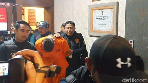 Buronan Interpol Costinel-Cosmin Zuleam menunduk saat digiring ke mobil tahanan di Polda Bali, Selasa (20/1/2026).