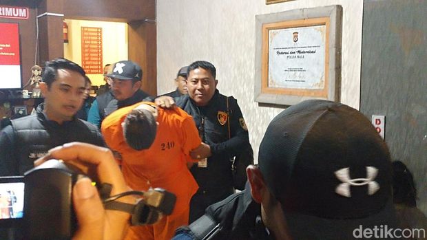 Buronan Interpol Costinel-Cosmin Zuleam menunduk saat digiring ke mobil tahanan di Polda Bali, Selasa (20/1/2026).