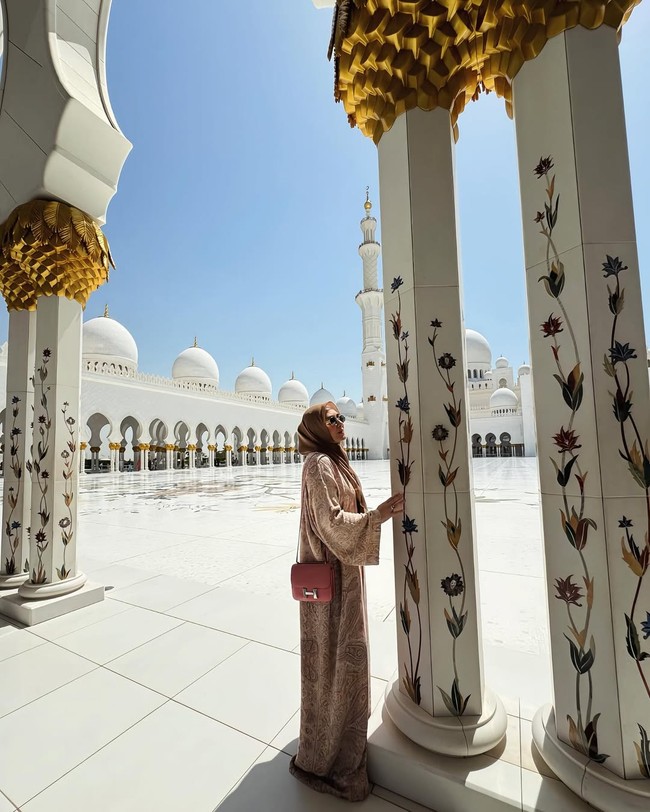 Vie Shantie Khan mengunjungi masjid Agung Sheikh Zayed di Abu Dhabi, ia memadukan dress bahan satin dengan Hermès Constance 18 Rouge H Epsom.  Foto: Dok. Instagram @vieshantiekhan.