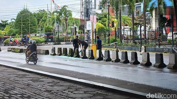 Petugas kebersihan membersihkan serpihan kaca Mal Panakkukang (MP) Makassar yang berhamburan di jalanan.