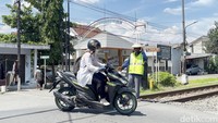 Ia tak hanya menutup palang, tapi juga terkadang mengingatkan pengendara yang nekat menerobos.