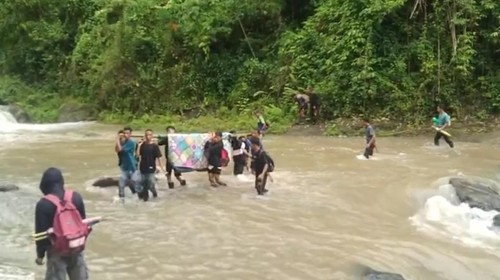 Warga Desa Baturotok Kecamatan Batu Lanteh, Kabupaten Sumbawa, Nusa Tenggara Barat, (NTB) menyebrangi sungai besar saat membawa jenazah, Selasa, (20/1/2026).