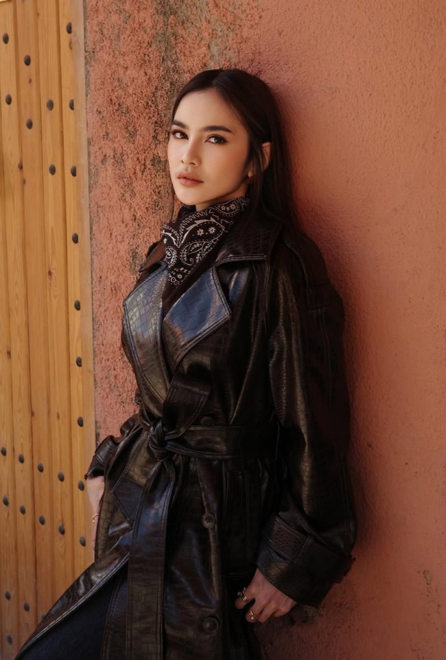 Ia memadukan coat tersebut dengan atasan bernuansa gelap dan scarf motif bandana yang dililit di leher. Aksen scarf ini memberi sentuhan klasik sekaligus mempermanis tampilan keseluruhan. Foto: Instagram/@mahaliniraharja