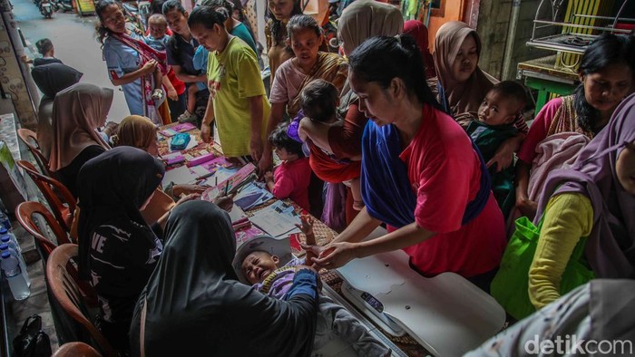Sejumlah petugas dasawisma bersama petugas Puskesmas Kalibaru melayani balita dan batita dalam kegiatan posyandu yang digelar di kawasan permukiman Kalibaru, Cilincing, Jakarta Utara, Rabu (21/1/2026). Sejak pagi, para ibu tampak antusias membawa anak-anak mereka ke lokasi posyandu untuk mendapatkan pelayanan kesehatan rutin, mulai dari penimbangan berat badan, pengukuran tinggi badan, pemeriksaan tumbuh kembang, hingga pemberian vitamin dan imunisasi sesuai jadwal