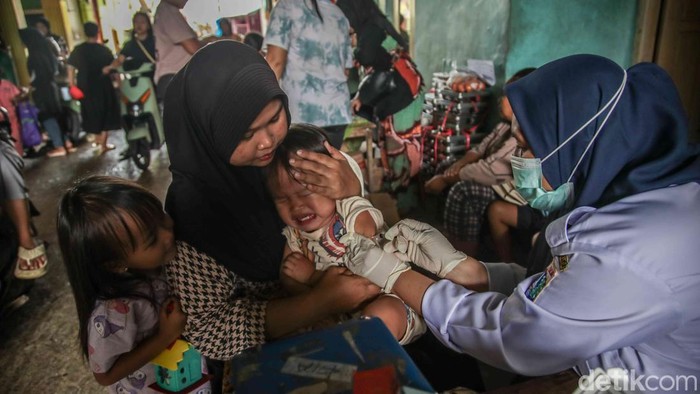 Sejumlah petugas dasawisma bersama petugas Puskesmas Kalibaru melayani balita dan batita dalam kegiatan posyandu yang digelar di kawasan permukiman Kalibaru, Cilincing, Jakarta Utara, Rabu (21/1/2026). Sejak pagi, para ibu tampak antusias membawa ana