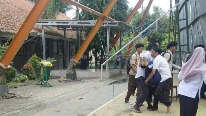 Sejumlah siswa dan guru saat mengevakuasi korban