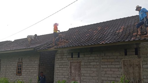 Sejumlah warga Desa Penyaringan, Kecamatan Mendoyo, Jembrana, Bali, memperbaiki atap rumah yang rusak diterjang angin puting beliung, Rabu (21/1/2026). (Foto: Dok. Polres Jembrana)