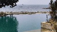 Tak jauh dari bibir pantai, sebuah kolam renang menghadap langsung ke laut.