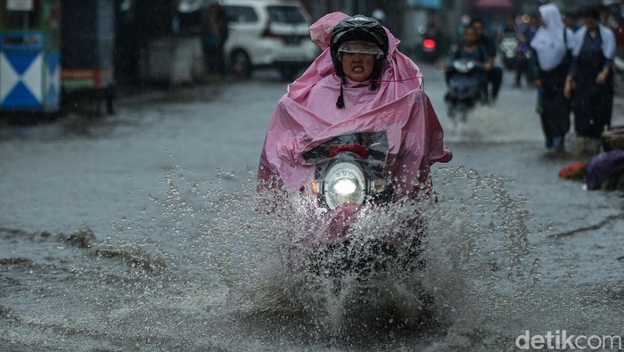 Hujan deras membuat Jalan Puri Cendana, Bekasi, tergenang banjir, Rabu (22/1/2026). Pelajar dan pengendara nekat menerobos genangan.