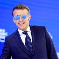 Mengenakan kacamata hitam saat menjadi pembicara di sebuah pertemuan resmi dunia tentu bukan pilihan lumrah. Maka ketika Macron muncul dengan aksesori tersebut di Forum Ekonomi Dunia (WEF) 2026, sorotan pun langsung tertuju padanya. (Foto: REUTERS/Denis Balibouse)