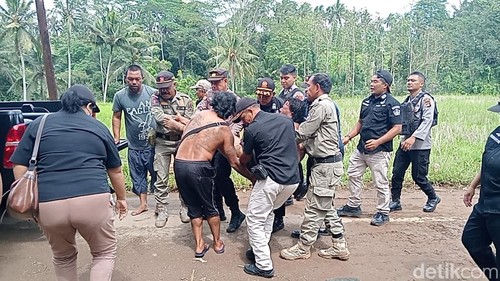 Satpol PP Bangli, polisi, dan warga Desa Demulih, Kecamatan Susut, Bangli, berupaya menenangkan pensiunan TNI saat mengamuk dalam keadaaan telanjang, Kamis (22/1/2026).