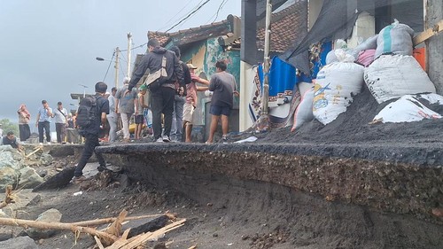 Warga Bugis, Ampenan, mulai memasang karung berisikan pasir agar air pantai tidak masuk ke dalam rumahnya, Kamis (22/1/2026). (Nathea Citra/detikBali)