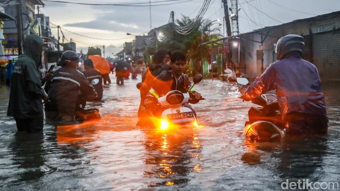 Warga melintasi genangan banjir di kawasan Marakash, Pondok Ungu, Kabupaten Bekasi, Jawa Barat, Kamis (22/1/2026), di tengah peringatan cuaca ekstrem.
