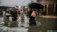 Warga melintasi banjir di kawasan Marakash, Pondok Ungu, Kabupaten Bekasi, Jawa Barat. Genangan air menutup akses jalan permukiman dan menghambat mobilitas warga akibat hujan dengan intensitas tinggi yang mengguyur wilayah tersebut.