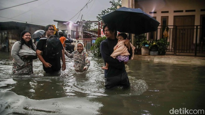 Warga melintasi genangan banjir di kawasan Marakash, Pondok Ungu, Kabupaten Bekasi, Jawa Barat, Kamis (22/1/2026), di tengah peringatan cuaca ekstrem.