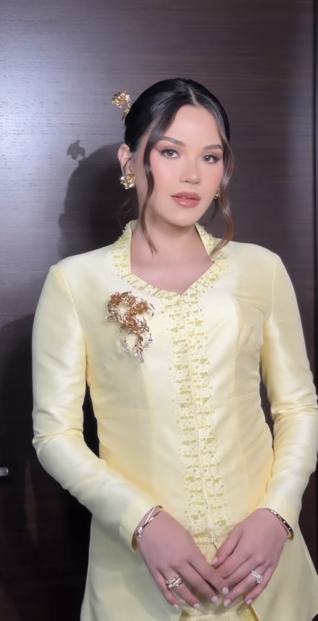 Kompak dengan para anggota keluarga, Alyssa juga mengenakan busana berwarna kuning rancangan Asky Febrianti. Busana tersebut dipercantik dengan detail bordir serta payet kecil berwarna senada yang menghiasi bagian depan dan garis leher. Pada bagian dada, Alyssa menyematkan bros emas bermotif floral. Foto: Instagram/@alyssadaguise/@bennusorumba