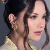 Rambut Alyssa ditata dalam sanggul rapi bergaya modern dengan belahan tengah. Dua helaian rambut yang dibiarkan menjuntai di sisi wajah memberi sentuhan soft dan romantis, memperhalus garis wajahnya. Foto: Instagram/@alyssadaguise/@bennusorumba