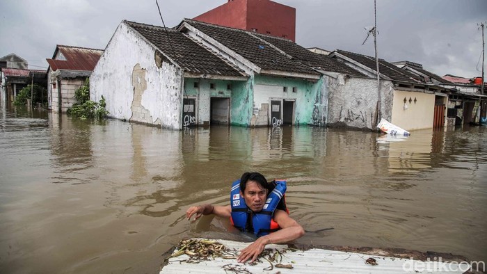 Sejumlah warga masih beraktivitas di tengah banjir yang merendam kawasan Perumahan Subsidi Green Permata Residence, Tambun Utara, Kabupaten Bekasi, Jawa Barat, Jumat (23/1/2026). Banjir di perumahan tersebut terbilang parah dengan ketinggian air mencapai leher orang dewasa atau sekitar 1,5 meter.
