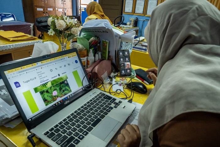 Guru memberikan pembelajaran jarak jauh (PJJ) kepada siswa di SMP Negeri 26, Jakarta, Jumat (23/1/2026). Dinas Pendidikan DKI Jakarta mengeluarkan Surat Edaran (SE) Nomor 9/SE/2026 terkait pelaksanaan PJJ bagi seluruh satuan pendidikan di ibu kota yang berlaku hingga 28 Januari 2026 akibat cuaca ekstrem yang melanda Jakarta.