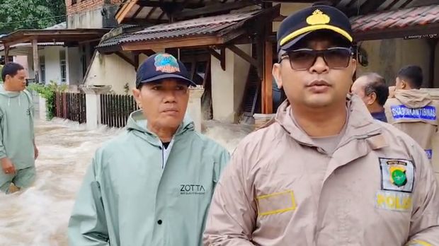 Kapolsek Pinang Iptu Adityo Wijanarko mengecek tanggul Kali Angke yang jebol, Jumat (23/1/2026).