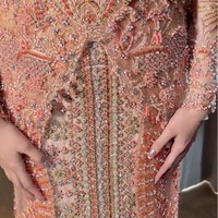 Kebaya dipadukan dengan kain berhias payet serta kristal yang dirangkai membentuk motif tumpal. Kombinasi warna terakota lembut, peach dan beige menghasilkan busana yang tampak mewah sekaligus elegan. Foto: Instagram/@studiboh @rhay_david