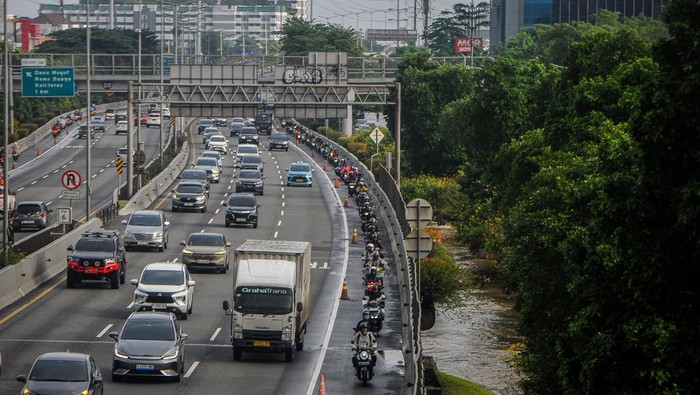 Pengendara sepeda motor melintas di Jalan Tol Lingkar Luar untuk menghindari banjir di Cengkareng, Jakarta, Jumat (23/1/2026). Banjir setinggi 40-60 cm akibat tingginya intensitas hujan sejak Kamis (22/1) serta buruknya kualitas drainase tersebut membuat sejumlah kendaraan mogok dan lalu lintas terganggu. ANTARA FOTO/Naufal Khoirulloh/foc.