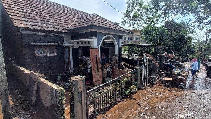 Sejumlah warga membersihkan material lumpur akibat banjir bandang yang melanda wilayah Desa Sangkanayu, Kecamatan Mrebet, Kabupaten Purbalingga, Sabtu (24/1/2026).