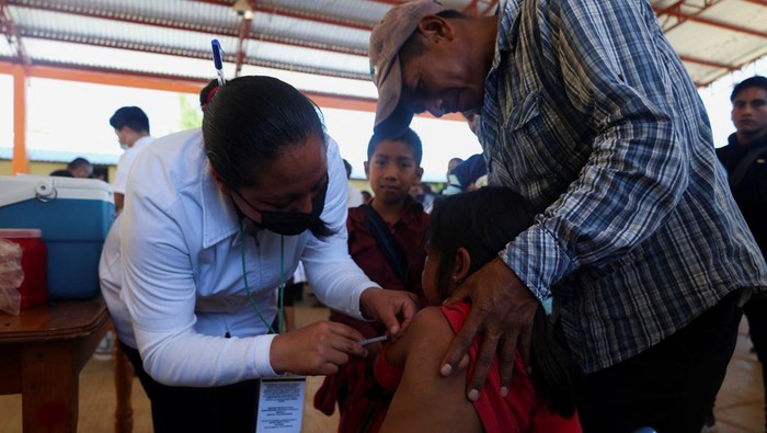 Anak-anak hingga warga lanjut usia dari komunitas adat Tzajalhucum mengikuti kampanye vaksinasi campak yang digelar di San Juan Cancuc, negara bagian Chiapas, Meksiko, Sabtu (24/1/2026). Program ini dilakukan sebagai upaya menekan penyebaran wabah campak yang kembali merebak di wilayah tersebut. REUTERS/Damian Sanchez
