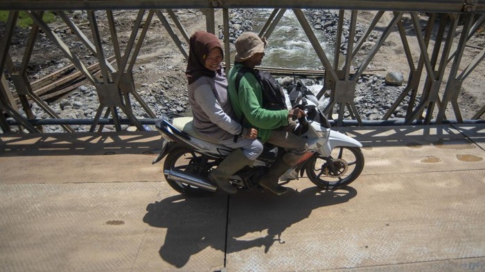 Warga melintasi jembatan bailey di Jorong Aia Taganang, Matur, Agam, Sumatera Barat, Minggu (25/1/2026). TNI-AD menyelesaikan pembangunan satu unit jembatan bailey yang menghubungkan Kecamatan Matur dan Palupuh, Agam, karena jembatan permanen hancur akibat banjir bandang pada November 2025. ANTARA FOTO/Iggoy el Fitra