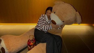 Potret Jennie tidur di atas pangkuan boneka beruang berukuran jumbo. (Foto: dok. Instagram @jennierubyjane)