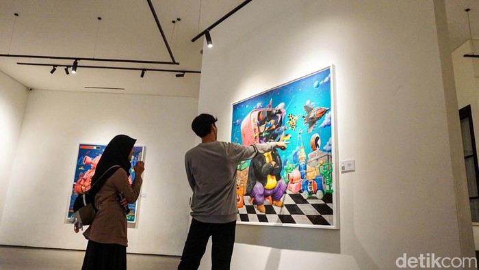 Pameran seni rupa Small Talks for Serious Times karya Nyoman Suarnata ramai dikunjungi publik di Galeri Zen1, Jakarta Pusat, Minggu (25/1/2026). Sejumlah pengunjung terlihat berdiri lama di depan karya, berpindah dari satu lukisan ke lukisan lainnya, sambil berdiskusi pelan mengenai pesan yang tersirat di balik setiap karya.