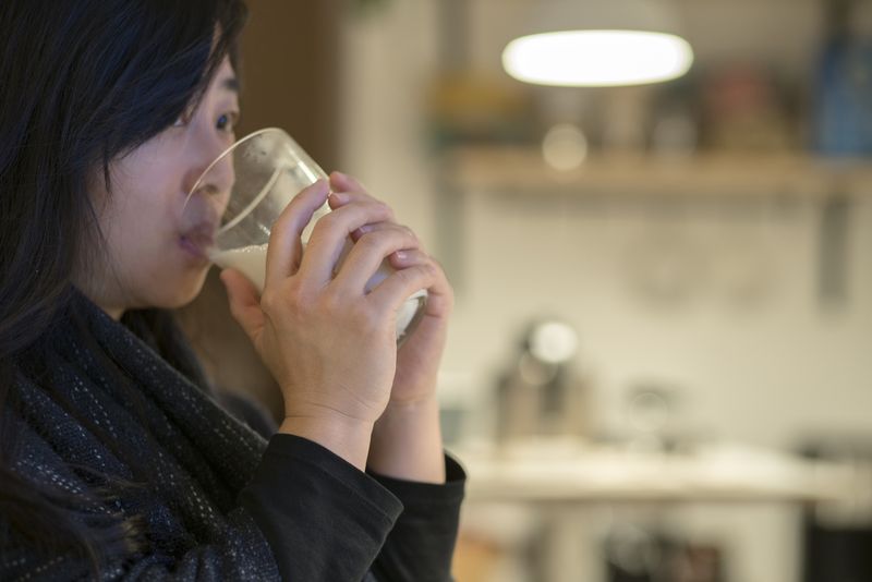 young girl drinking milk at night