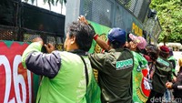 Petugas kepolisian berjaga dan memasang barikade besi untuk mengamankan jalannya aksi unjuk rasa yang berlangsung tertib dan kondusif.