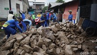 Petugas Dinas Sumber Daya Air (SDA) memindahkan batu kali untuk pembangunan turap bronjong di bantaran Kali Angke, Kembangan Selatan, Jakarta Barat, Senin (26/1/2026).  