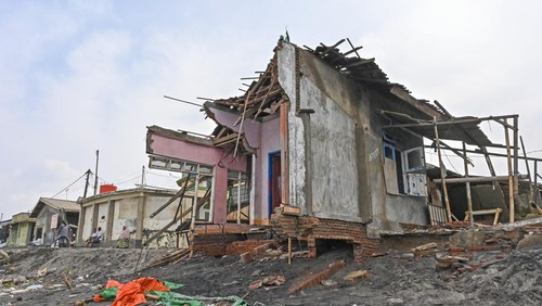 Warga berada dekat rumah yang rusak diterjang gelombang tinggi di pesisir kampung nelayan, Lingkungan Bugis, Ampenan, Mataram, NTB, Senin (26/1/2026). Akibat terjangan gelombang tinggi yang terjadi sejak empat hari lalu menyebabkan abrasi dan sebanyak delapan belas rumah nelayan mengalami kerusakan dan terkubur pasir yang terbawa gelombang tinggi.ANTARA FOTO/Ahmad Subaidi/nz