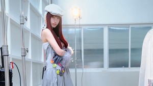 Liz bergaya rambut merah, mengenakan topi beret berwarna senada dengan gaunnya. (Foto: dok. Starship Entertainment)