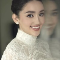 Rambutnya ditata dengan model sleek bun dengan belahan tengah yang rapi. Tampilan tersebut memberikan kesan anggun, elegan, dan timeless. Foto: Instagram/@andychunmakeup