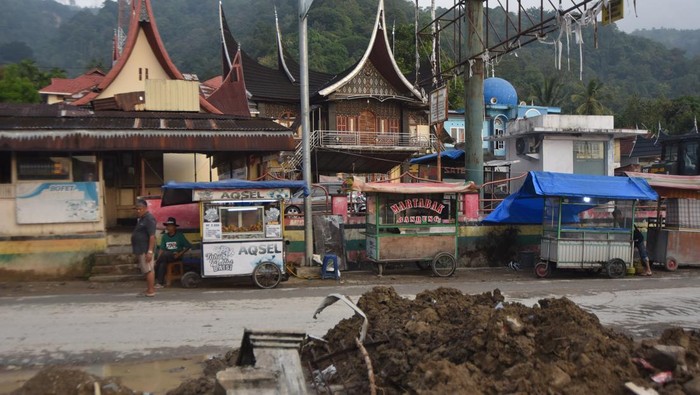 Warga berjualan kelapa muda di lokasi terdampak bencana banjir bandang di Nagari Maninjau, Tanjung Raya, Agam, Sumatera Barat, Senin (26/1/2026). Warga dan pedagang mulai berjualan untuk menghidupkan kembali roda perekonomian di kawasan wisata Danau Maninjau yang sempat terhenti akibat bencana pada November 2025. ANTARA FOTO/Iggoy el Fitra