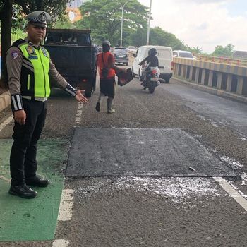 Sebuah video memperlihatkan pemotor terjatuh karena jalan berlubang di Jalan Juanda, Depok. Polisi bersama Dinas PUPR Kota Depok menambal jalan rusak. (dok Polres Depok)