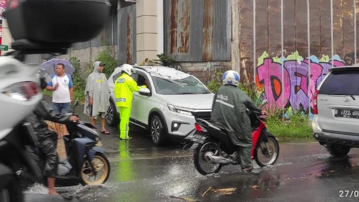 Dampak hujan angin di Sleman, satu unit mobil tertimpa pohon tumbang.