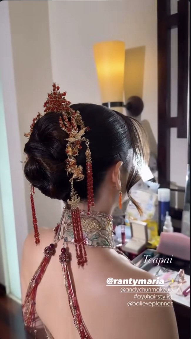 Rambut Ranty ditata dengan model bun rapi lengkap dengan hairpiece emas dengan detail floral dan tassel merah, khas aksesori pengantin Tiongkok. Beberapa helai rambut dibiarkan jatuh lembut di sisi wajah untuk memberi efek soft dan feminin. Foto: Instagram