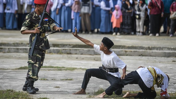 Pelajar berlari dengan membawa bendera Merah Putih saat mementaskan drama teatrikal Perjuangan Merah Putih ke-79 Sangasanga di Taman Palagan, Sangasanga, Kutai Kartanegara, Kalimantan Timur, Selasa (27/1/2026). Penampilan aksi teatrikal dari gabungan pelajar itu menggambarkan peristiwa bersejarah Merah Putih dalam memperjuangkan dan mempertahankan Sangasanga yang terjadi pada 79 tahun silam. ANTARA FOTO/M Risyal Hidayat/wsj.