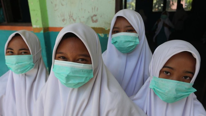 Petugas medis dari Pukesmas Samatiga membantu memakaikan masker kepada pelajar di Madrasah Tsanawiyah Negeri (MTsN) Blang Bale, Kecamatan Samatiga, Aceh Barat, Aceh, Selasa (27/1/2026). Sebanyak 600 masker dibagikan kepada siswa-siswi untuk mengantisipasi penyakit Infeksi Saluran Pernafasan Akut (ISPA) seiring semakin tebalnya kabut asap dampak Kebakaran Hutan dan Lahan (Karhutla) yang terus meluas di Kabupaten setempat. ANTARA FOTO/Syifa Yulinnas/wsj.