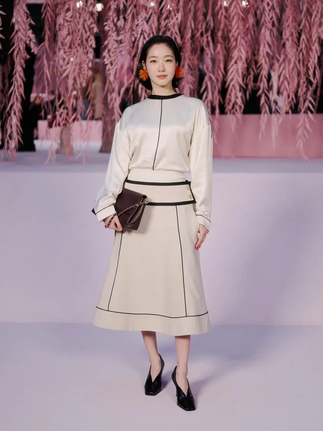Bintang film ‘Exhuma’ ini memilih gaya minimalis dengan padanan blouse dan rok warna beige berdetail list hitam. Kim Go Eun menyempurnakan penampilannya dengan clutch dan sepatu V-vamps. Foto: Instagram/@chanelofficial @ggonekim