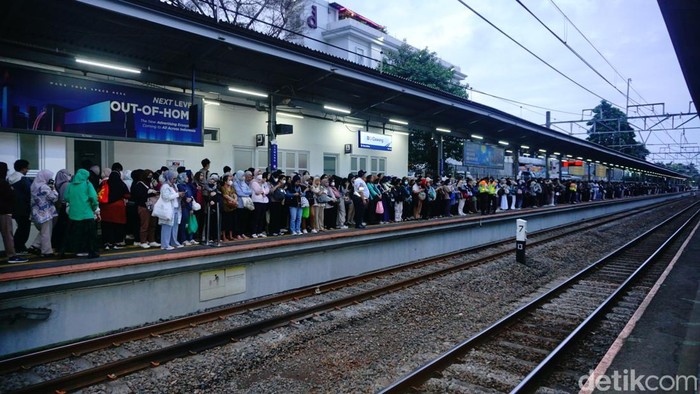 Peron KRL jurusan Bogor di Stasiun Cawang dipadati penumpang saat jam pulang kantor. Antrean mengular dan penumpang berdesakan menunggu kereta datang.