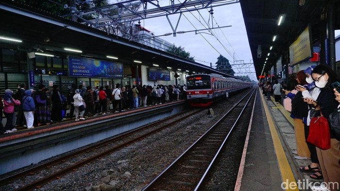 Peron KRL jurusan Bogor di Stasiun Cawang dipadati penumpang saat jam pulang kantor. Antrean mengular dan penumpang berdesakan menunggu kereta datang.