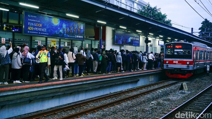 Peron KRL jurusan Bogor di Stasiun Cawang dipadati penumpang saat jam pulang kantor. Antrean mengular dan penumpang berdesakan menunggu kereta datang.
